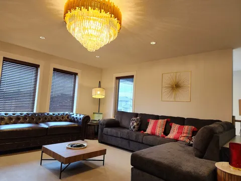 Living room with sofas, a coffee table, windows and a ceiling light.