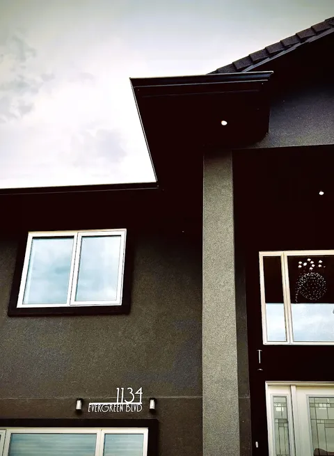 Covered entrance with house number 1134, an upper window and light fixtures.