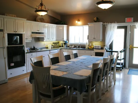 Shared kitchen and dining table beneath a pendant light.