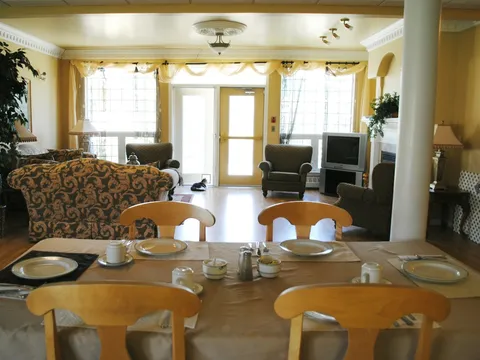 Dining table with wood chairs beside a shared sitting area.