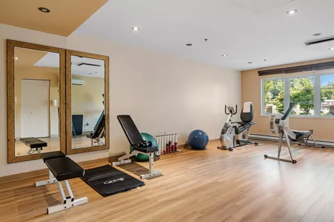 Fitness room with exercise machines, mirrors and a blue ball