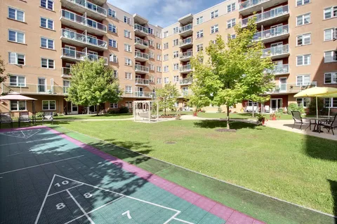 Residence courtyard with a lawn, trees and shuffleboard court