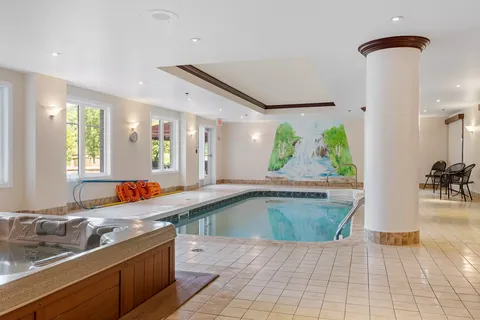 Indoor swimming pool with tiled surroundings and a landscape mural