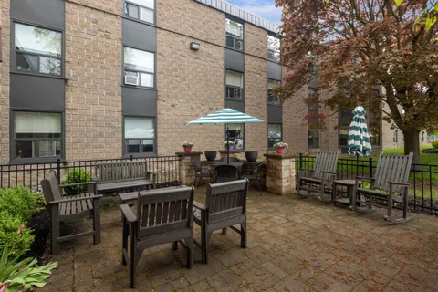 Patio with tables, chairs and umbrellas beside the building.