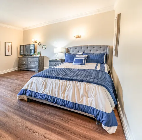 Bedroom with a double bed, bedside tables and wooden flooring.