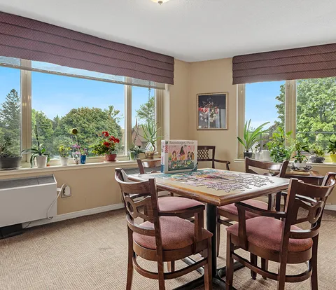 Games room with a table and chairs beside large windows.