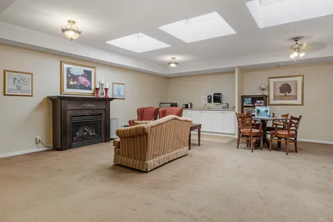 Lounge with a fireplace, sofa and games table.
