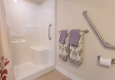 Shower with a built-in seat, grab rails and towels