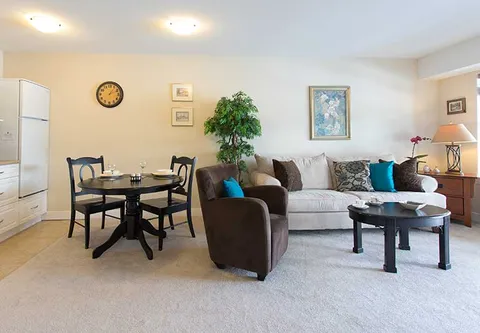 Open room with a sofa, armchair, dining table and kitchen appliances