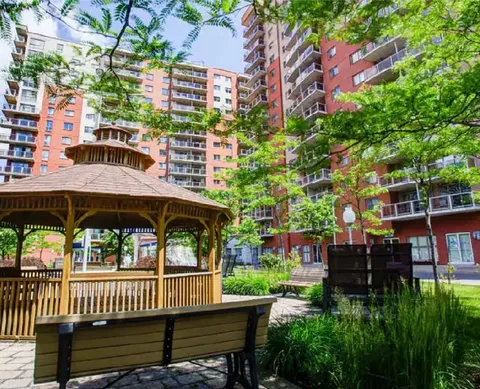 Residence towers around a garden courtyard with a wooden gazebo and benches