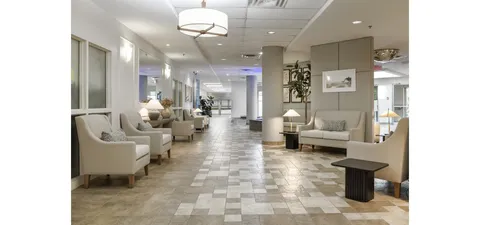 Seating area with cream armchairs, sofas and a tiled corridor