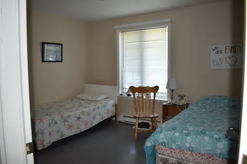 Shared bedroom with two single beds and a table.