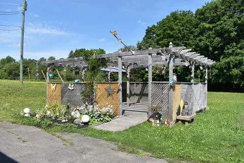 Garden pergola with outdoor seating and planted beds.