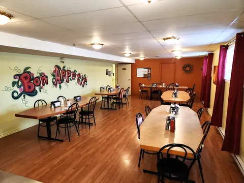 Dining room with wooden tables, black chairs and orange and green walls