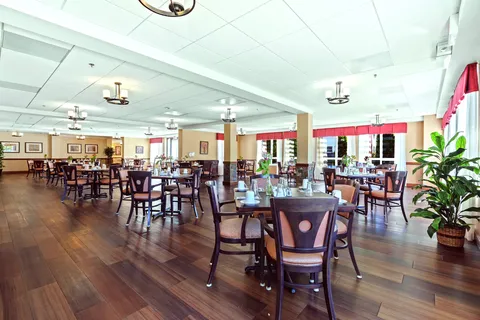 Dining room with dark wooden tables and chairs beside large windows