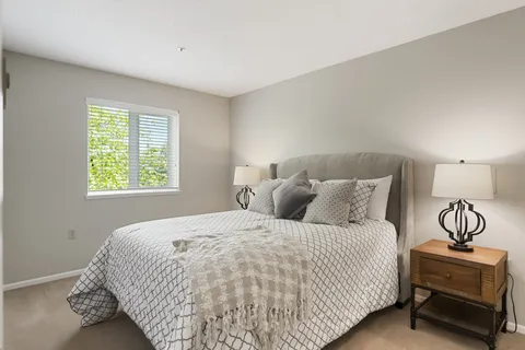 Suite bedroom with a bed, bedside table and window.