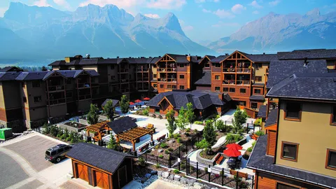 Aerial view of the residence buildings and courtyard with mountains in the background.
