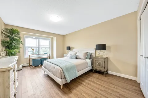 Bedroom with a double bed, bedside lamps, dresser and window