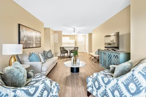 Suite sitting area with a sofa, patterned armchairs, a television and a kitchenette