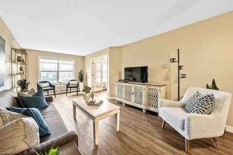 Sitting area with a sofa, armchairs, coffee table and television