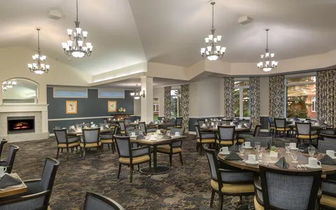 Grande dining room with tables, chandeliers and fireplace.
