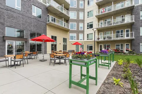 Courtyard patio with tables, red umbrellas and raised garden beds