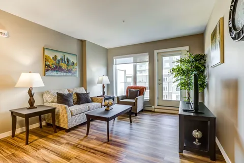 Sitting area with a sofa, armchair, coffee table and glazed balcony door