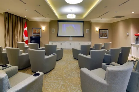 Cinema room with rows of armchairs and a projection screen