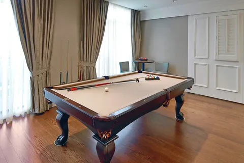 Games room with a pool table beside large windows