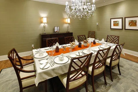 Private dining room with a long table beneath a chandelier