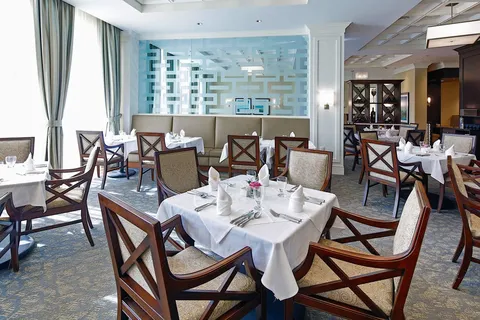 Dining room with set tables beside large windows