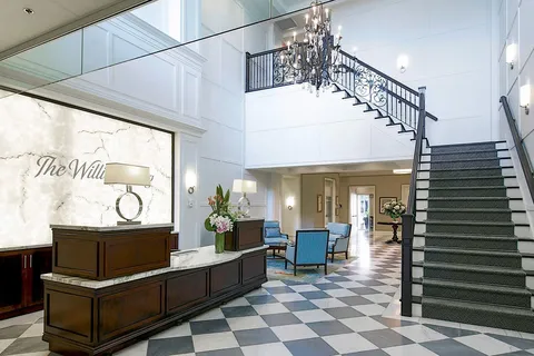 Lobby with a reception desk, chandelier and curved staircase