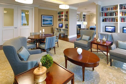 Library lounge with armchairs, bookshelves and a reading table