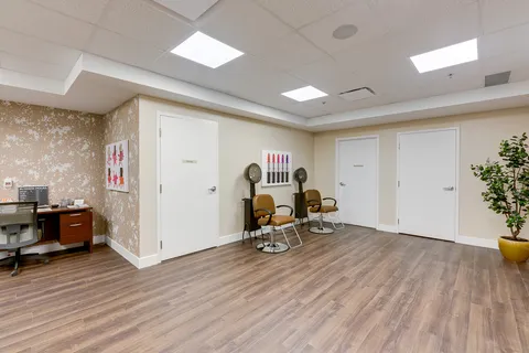 Salon with two hooded hair dryers, brown chairs and lipstick artwork