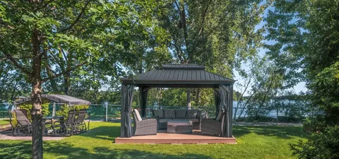 Gazebo with cushioned seating beside a river