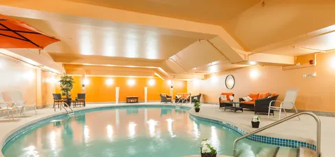 Indoor pool with handrails and lounge seating