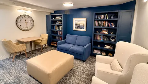 Reading lounge with chairs, sofa and blue bookshelves.