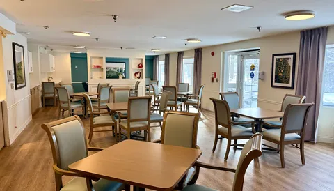 Dining room with tables, chairs and large windows.