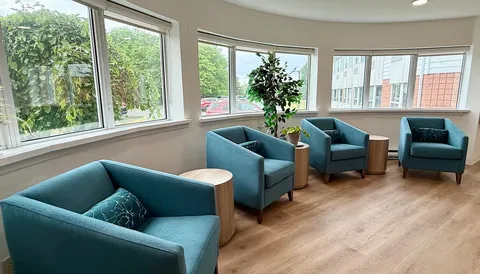 Window-side seating area with blue armchairs.