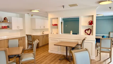 Small dining and serving area with cabinets and tables.