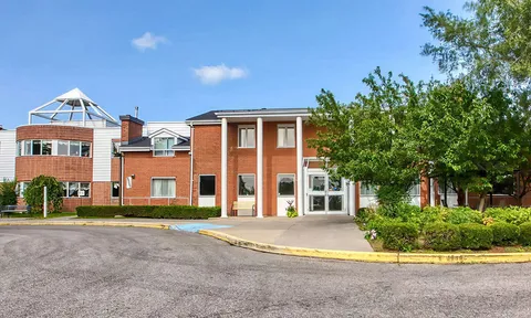 Residence exterior with a covered entrance and landscaped beds.