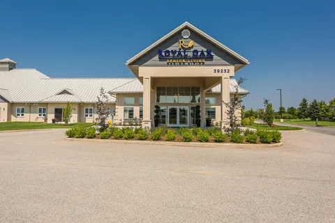 Building entrance with a peaked canopy, stone pillars and glass doors