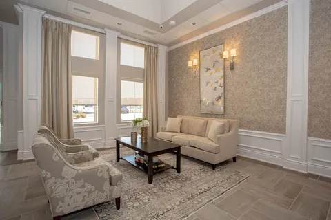 Sofa and armchairs beside tall windows and a coffee table
