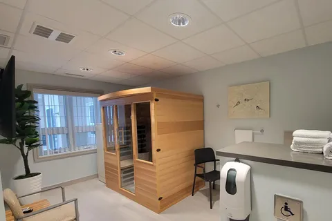 Wooden sauna cabin beside a counter, towels and a chair