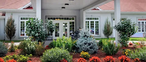 Planted garden beds in front of the residence windows.