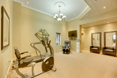 Fitness room with exercise equipment, reclining chairs and a blank television