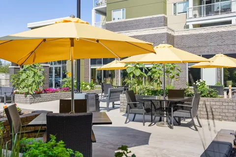 Patio seating beneath yellow umbrellas beside the building