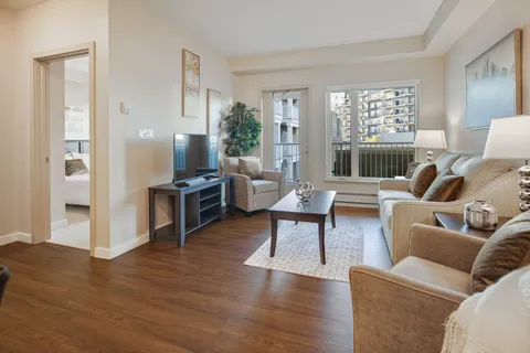 Sitting area with a sofa, television and balcony door