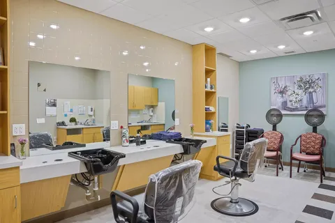 Hair salon with styling chairs, wash basins and hood dryers
