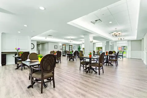Dining room with wooden tables, chairs and flower arrangements